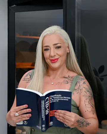 Luciane Capassi com o livro de Classificação de Transtornos Mentais CID-10